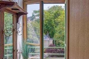 una ventana abierta con vistas a una casa en Le Verlaine - appt charmant cosy idéalement situé en Calais