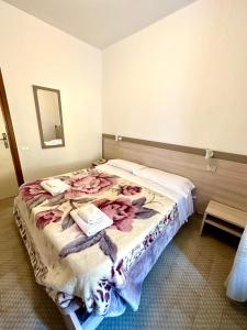 a bedroom with a large bed with flowers on it at Hotel Aurora in La Spezia