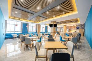 a dining room with tables and chairs at Holiday Inn Express Jurong Xianlin in Zhenjiang