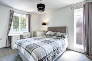 um quarto com uma cama, uma secretária e janelas em Sunderland Short Stays 2 bedroom apartment Free Parking Fulwell SR6 em Sunderland