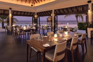 a restaurant with tables and chairs with the ocean in the background at Nova Maldives in Dhangethi