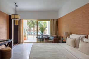 a bedroom with a large bed and a living room at Anantara Vilamoura Family Friendly in Vilamoura