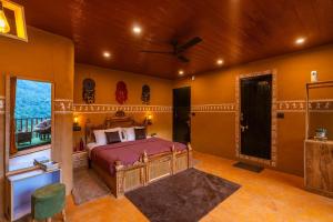 a bedroom with a bed and a ceiling fan at Dharamalaya by StayVista - The Eco Home in Dharamshala