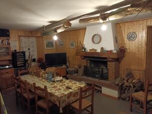 a dining room with a table and a fireplace at B&B Ca' dal Sol in Selvanizza