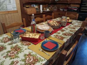 B&B Ca' dal Sol في Selvanizza: طاولة مع قطعة قماش مع الطعام وزجاجة