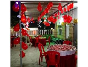 a patio with red lanterns and a table and chairs at Hotel Grace, Agra in Agra