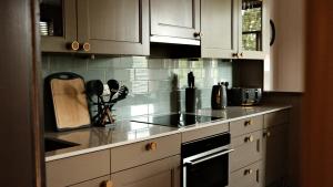 a kitchen with white cabinets and a counter top at The Lawrance Luxury Aparthotel - Harrogate in Harrogate