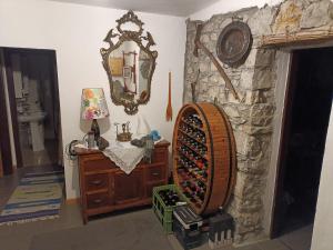 B&B Ca' dal Sol في Selvanizza: غرفة بجدار حجري مع مرآة وخزانة