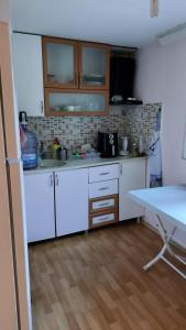 cocina con armarios blancos y suelo de madera en Mommy Farm home, en Beldibi