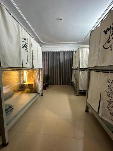 a hallway with beds in a room with writing on the walls at Home Tea An Yên Dorm in Ho Chi Minh City