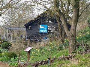 ein Schild an der Seite eines kleinen Gebäudes in der Unterkunft Landscape, New Eco Lodge Flatford Mill in East Bergholt