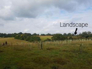 a field with a sign that reads language and a field with trees at Landscape, New Eco Lodge Flatford Mill in East Bergholt +56 photos