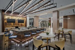 a lobby with a bar and tables and chairs at Marriott Fort Lauderdale Airport in Dania Beach