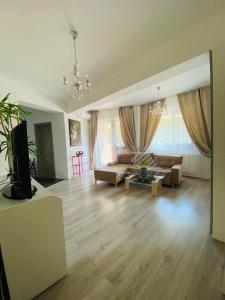 ein Wohnzimmer mit einem Sofa und einem Tisch in der Unterkunft Gloria’s Place in Bukarest