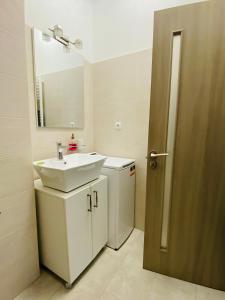 ein Bad mit einem Waschbecken und einem Spiegel in der Unterkunft Gloria’s Place in Bukarest
