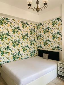 Bett in einem Zimmer mit einer Blumenwand in der Unterkunft Gloria’s Place in Bukarest