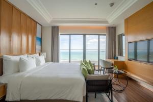 a bedroom with a large bed and a large window at Grand Hyams Hotel - Quy Nhon Beach in Quy Nhon