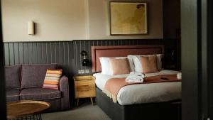 a hotel room with a bed and a chair at The Lawrance Luxury Aparthotel - Harrogate in Harrogate