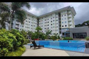 a large building with a swimming pool in front of it at Cozy Condo in San Jose Del Monte Bulacan Loft 2109 in Tunkong Manga