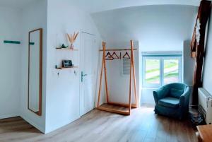 a room with a mirror and a blue chair at Ferme de Gratteloup in Courpalay