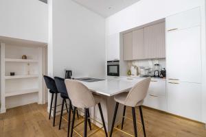 Luxury 3 bedrooms apartment - 6 persons - rue Hoche في كان: مطبخ أبيض مع طاولة وكراسي