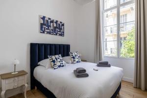 a bedroom with a large bed with blue and white pillows at Luxury 3 bedrooms apartment - 6 persons - rue Hoche in Cannes