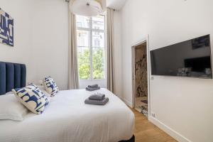 una camera con letto bianco, cuscini e TV di Luxury 3 bedrooms apartment - 6 persons - rue Hoche a Cannes