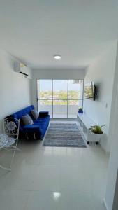 salon z niebieską kanapą i oknem w obiekcie Apartamento muy cerca al Mar de 3 habitaciones w mieście Cartagena de Indias