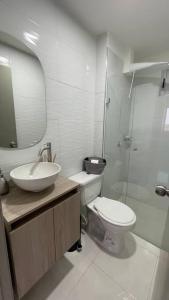 y baño con lavabo, aseo y espejo. en Apartamento muy cerca al Mar de 3 habitaciones, en Cartagena de Indias