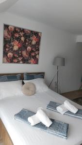 a white bed with two towels on top of it at Flowers in the Center in Oradea