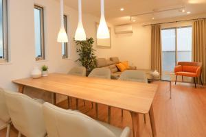 a living room with a wooden table and chairs at Shinjuku 1 Sta.・98㎡・4BR Entire Home Upscale Area in Tokyo