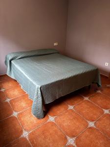 a bed in a room with a tiled floor at Villa Rosa Rasero 