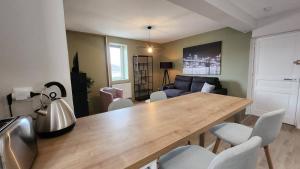 a living room with a wooden table and chairs at Les appartements de Louis in Limoges