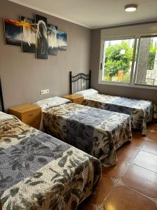 um quarto com três camas e uma janela em Villa Rosa Rasero 