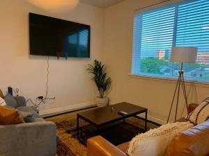 een woonkamer met een tv en een bank en een tafel bij Contemporary Cozy Apartment in Baltimore