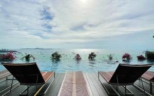 a swimming pool with two chairs in the water at 芭提雅Fnb Central 无边泳池 in Pattaya