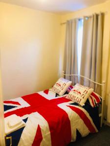 a bedroom with a red white and blue bed with pillows at Tatia House in Gainsborough