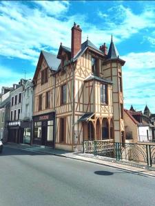 un grand bâtiment sur le côté d'une rue dans l'établissement La Maison à Pan De Bois chambre Art Deco, à Vierzon