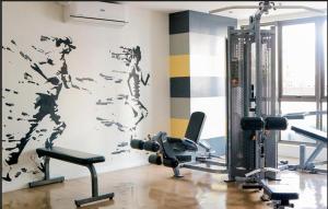 a room with a gym with a wall with birds painted on it at Condo hotel MAKATI GREENBELT in Manila