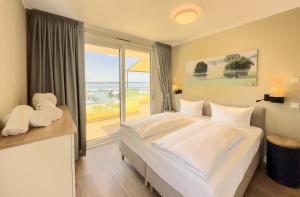 a bedroom with a large bed and a large window at Appartements "Zum Leuchtturm" Hafen Rankwitz Insel Usedom in Rankwitz