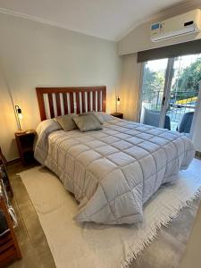 a bedroom with a large bed with a large window at Bungalow Don Árbol in Colón
