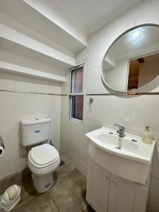 a white bathroom with a toilet and a sink at Bungalow Don Árbol in Colón