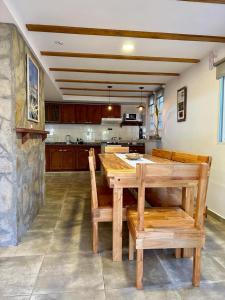 a kitchen with a wooden table and chairs in it at Bungalow Don Árbol in Colón +13 photos