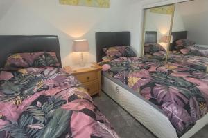 two beds sitting next to each other in a bedroom at River walk Cottage in Kincardine OʼNeil