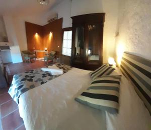 ein Schlafzimmer mit einem großen weißen Bett mit zwei Kissen in der Unterkunft Casa rural con encanto in Colmenar