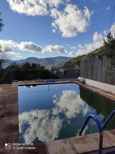 einen Pool mit Spiegelung des Himmels im Wasser in der Unterkunft Casa rural con encanto in Colmenar