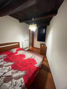 1 dormitorio con 1 cama con edredón rojo y blanco en B&B “La Torre”, en Trentinara