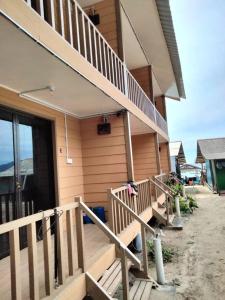 een huis met een houten trap en een balkon bij OCEANBOYS INN in Perhentian Island