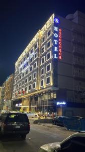 un grande edificio con un cartello sul lato di Sparrow Apartments Hotel a Gedda
