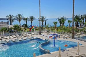 a large swimming pool with chairs and a water park at Nelia Beach Hotel & Spa in Ayia Napa